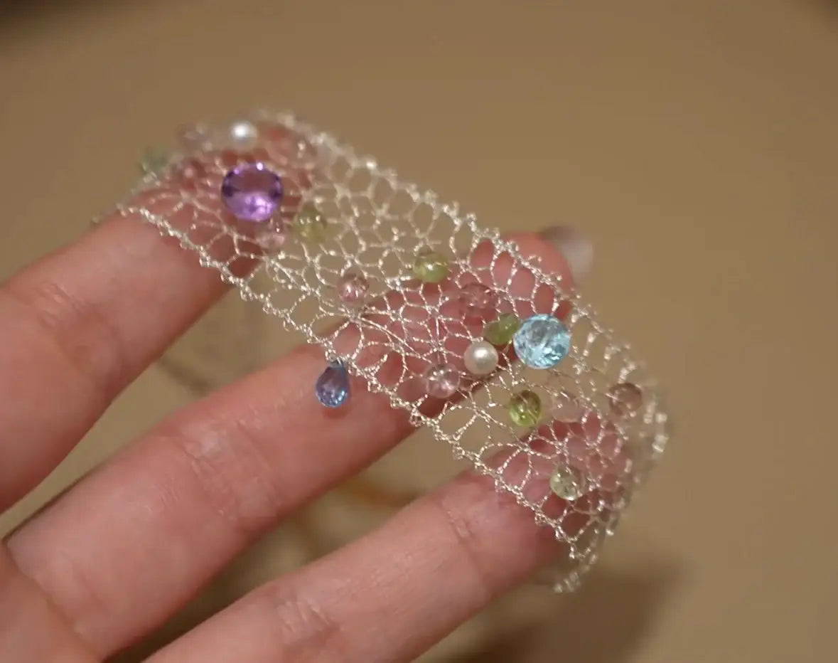 Delicate silver mesh bracelet with colorful gemstones and pearls, perfect for minimalist jewelry lovers.