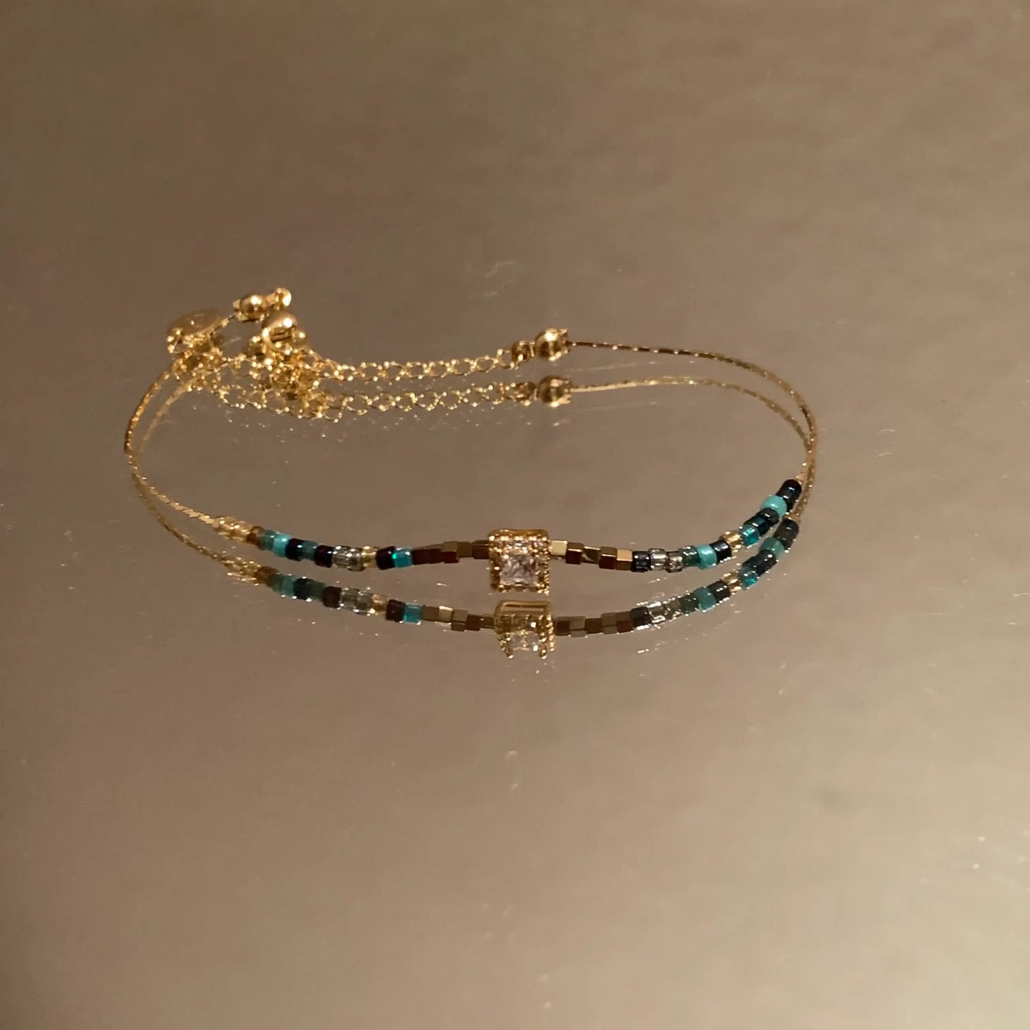 Minimalist gold bracelet with colorful beads and square crystal centerpiece