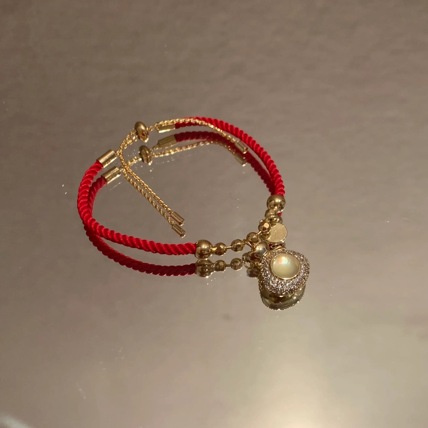 Red rope bracelet with gold beads and pearl charm, minimalist jewelry design