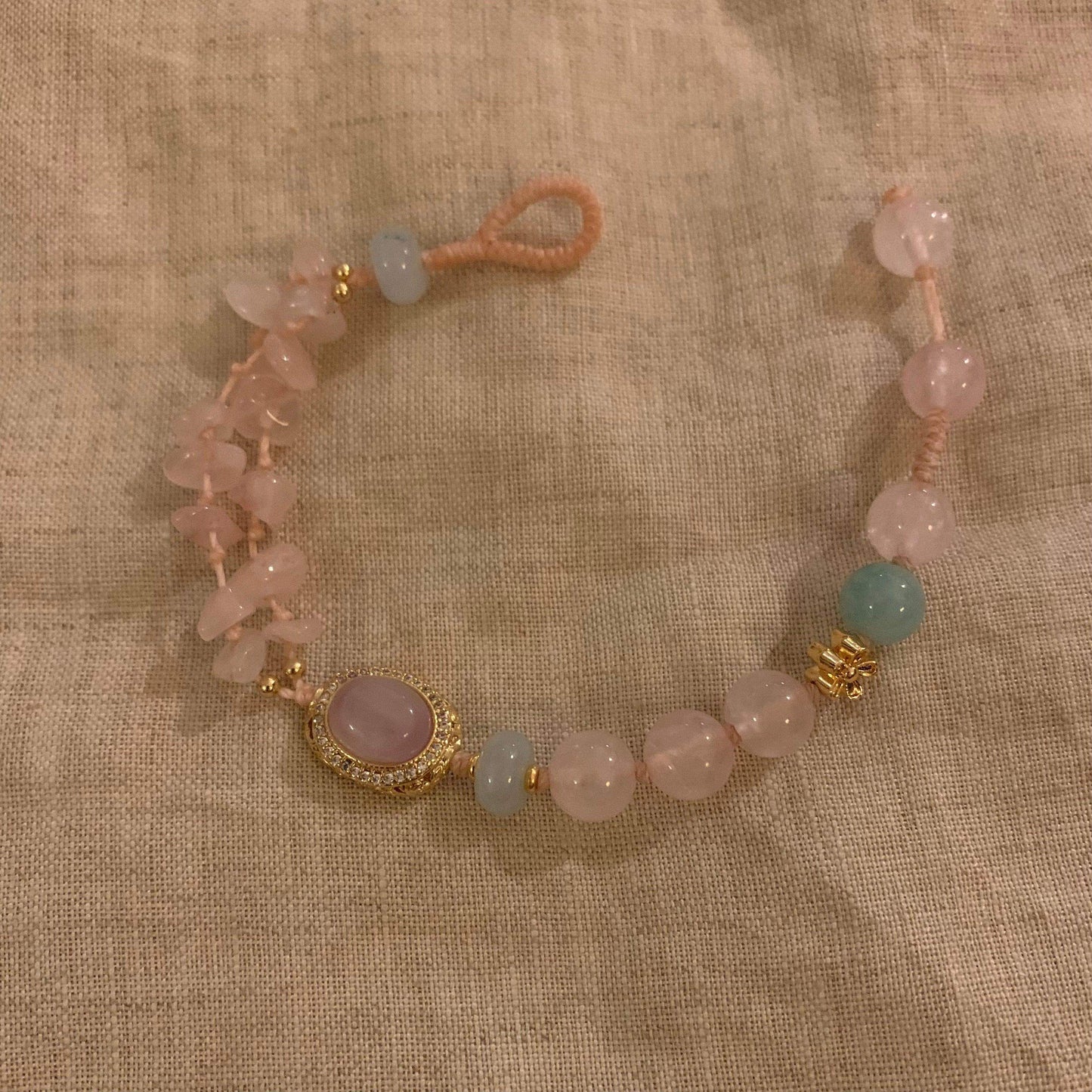 Handcrafted pink rose quartz bracelet with gold accents and aquamarine beads, minimalist design