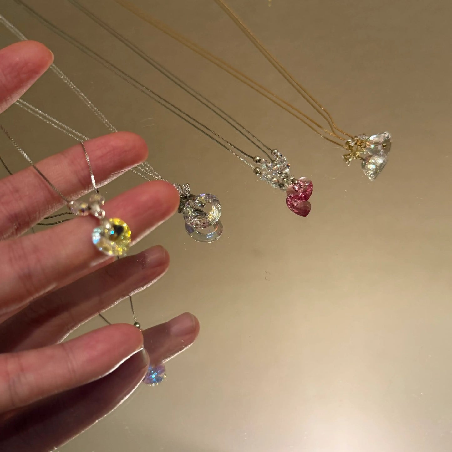 Elegant crystal necklaces with heart, flower, and round pendants in gold and silver tones