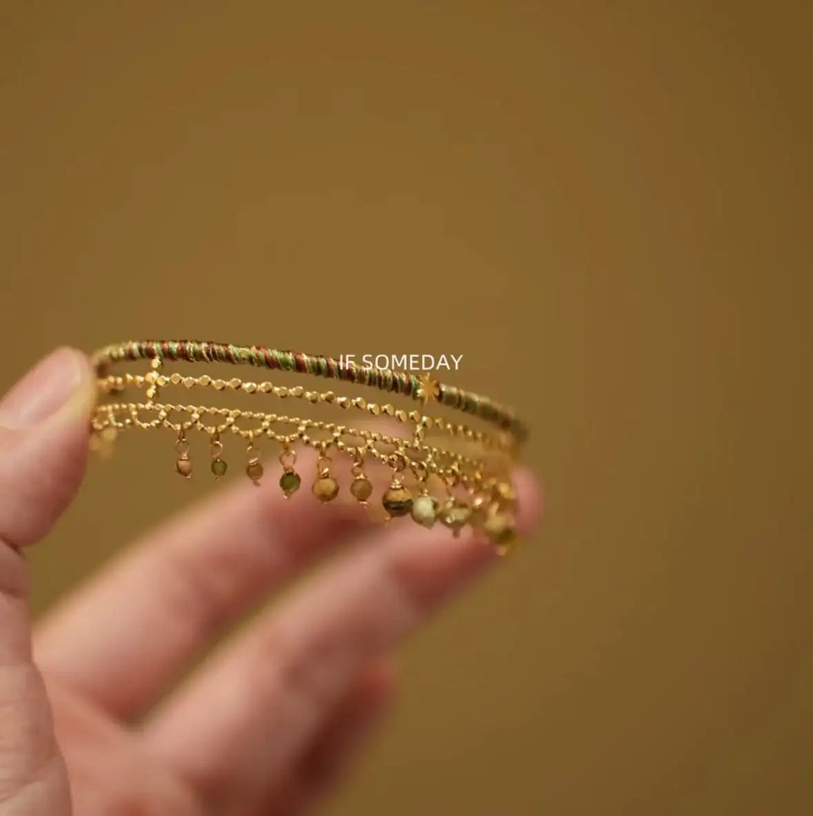 Delicate gold bracelet with colorful beads and dangling charms, handcrafted minimalist jewelry