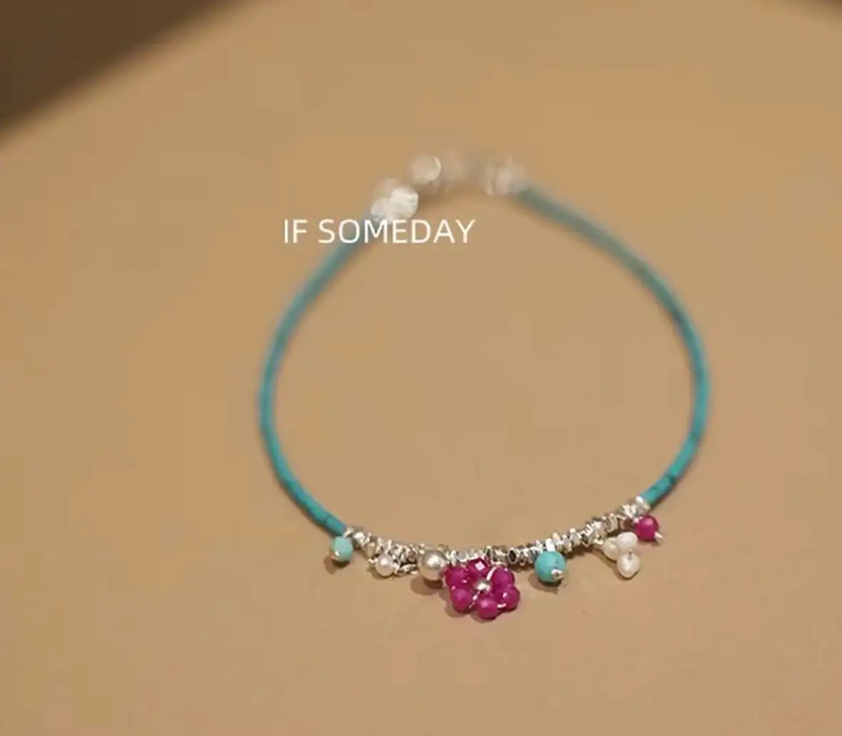 Delicate turquoise beaded necklace with pink flower charm and pearl accents, minimalist jewelry design