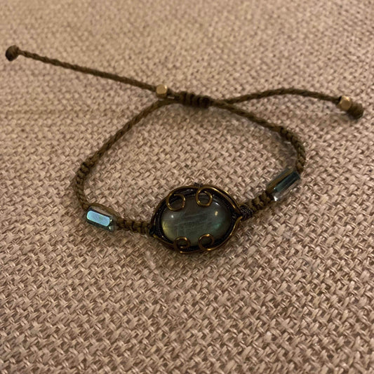 Handcrafted macrame bracelet with iridescent stone and gold wire detailing, perfect for minimalist jewelry lovers.