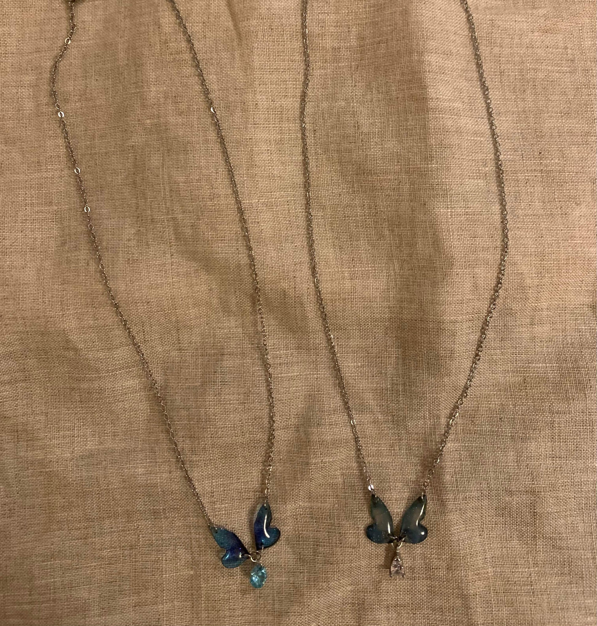 Minimalist butterfly pendant necklaces with blue and green gemstones on delicate chains