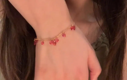 Delicate gold chain bracelet with dangling red gemstones, minimalist jewelry for everyday wear
