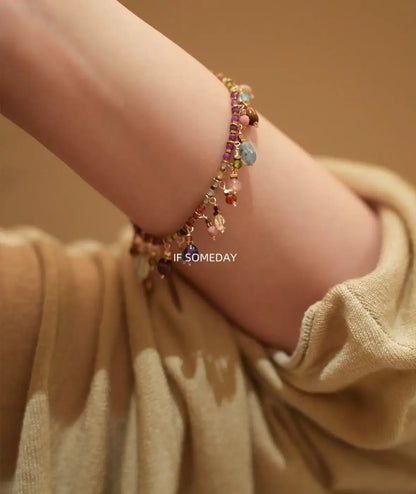 Colorful beaded bracelet with dangling charms on wrist, minimalist jewelry style