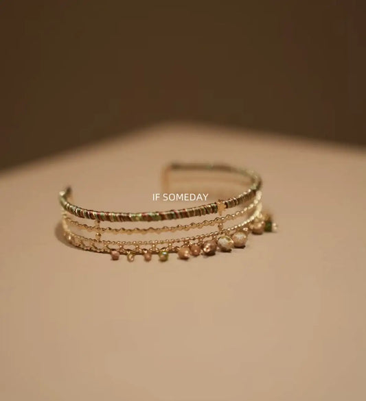 Layered gold bracelet with colorful beads and pearl charms, minimalist jewelry design
