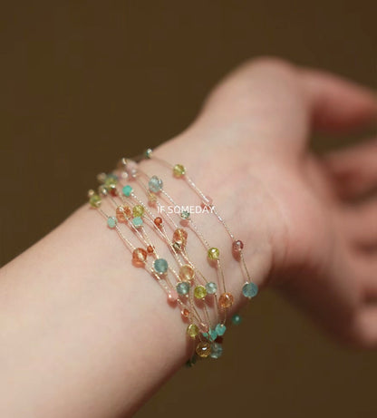 This multi-layered handmade bracelet is made of eight kinds of natural stones and features a silver clasp.