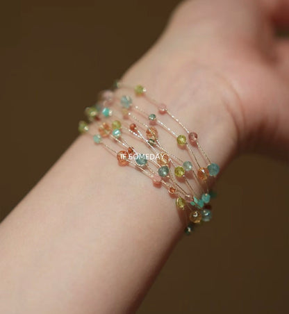 This multi-layered handmade bracelet is made of eight kinds of natural stones and features a silver clasp.