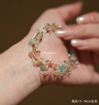 This multi-layered handmade bracelet is made of eight kinds of natural stones and features a silver clasp.